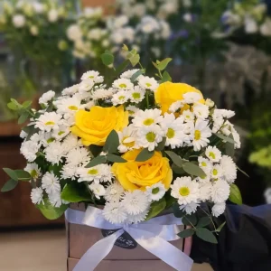 Arranjo de Flores Brancas e Amarelas em Caixa Kraft