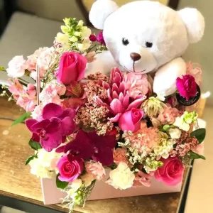 Arranjo de Flores Azuis na Maleta com Pelúcia